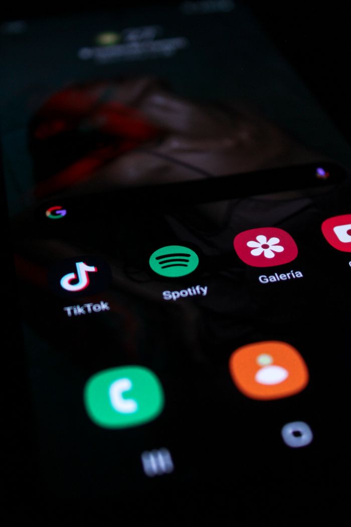 Vertical shot of a smartphone screen showing popular app icons like TikTok and Spotify.